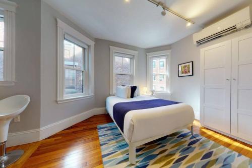 a bedroom with a bed and a sink and windows at A Stylish Stay w/ a Queen Bed, Heated Floors.. #12 in Brookline