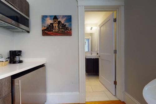 a kitchen with a white counter top and a hallway at A Stylish Stay w/ a Queen Bed, Heated Floors.. #12 in Brookline