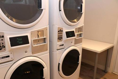 two washing machines are stacked next to each other at A Stylish Stay w/ a Queen Bed, Heated Floors.. #12 in Brookline