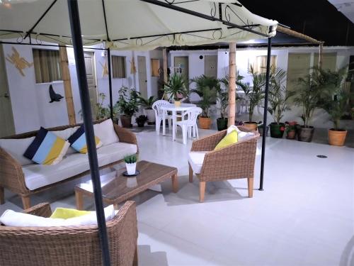 un patio con sillas, mesas y una sombrilla en Icthus Paracas, en Paracas
