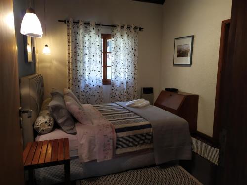ein kleines Schlafzimmer mit einem Bett und einem Fenster in der Unterkunft KasaBella Monte Verde in Monte Verde