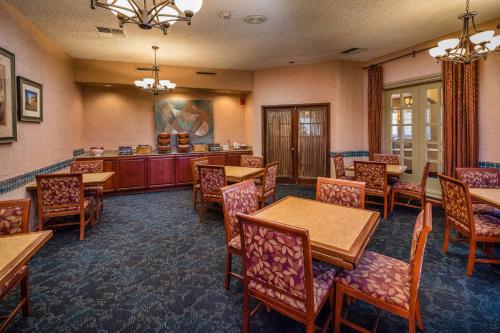 a dining room with tables and chairs and a bar at SFO El Rancho Inn SureStay Collection by Best Western in Millbrae