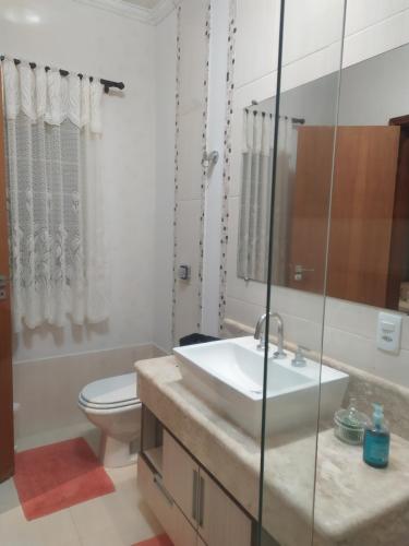 ein Bad mit einem Waschbecken, einem WC und einer Dusche in der Unterkunft KasaBella Monte Verde in Monte Verde