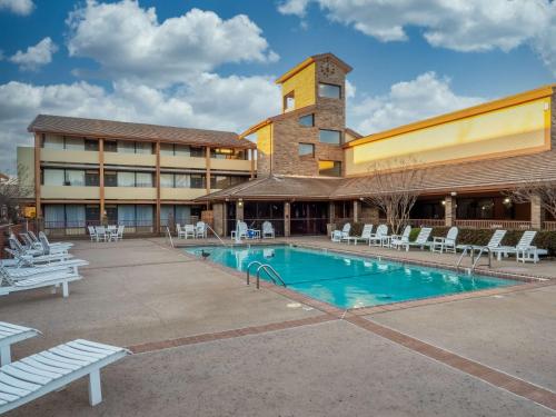a hotel with a swimming pool in front of a building at Best Western Plus Saddleback Inn and Conference Center in Oklahoma City