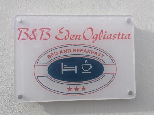 a sign for a bed and breakfast on a wall at B&B EDEN OGLIASTRA in Tortolì