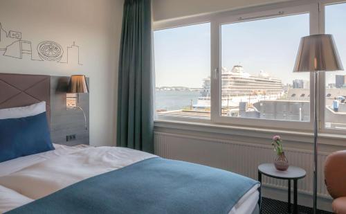 a hotel room with a bed and a window with a cruise ship at Radisson Blu Limfjord Hotel, Aalborg in Aalborg