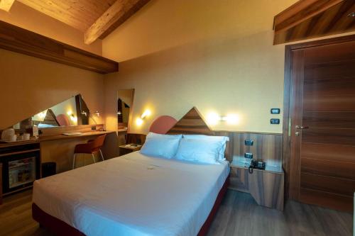 a hotel room with a bed and a desk at La Villa - Sure Hotel Collection by Best Western in Ivrea