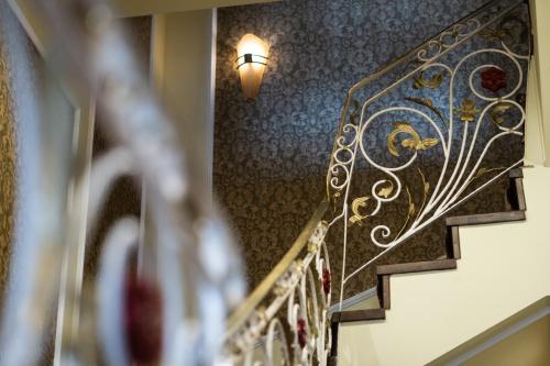 a stairway with a wrought iron railing and a light at Boutique Hotel Anagennisis in Pýrgos