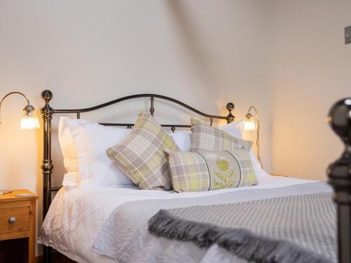 a bedroom with a bed with pillows on it at Hush Cottage in Middleton in Teesdale