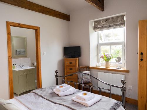 a bedroom with a bed and a sink and a window at Hush Cottage in Middleton in Teesdale