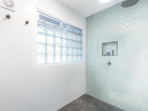 a bathroom with a shower with a window at Pippi Sands LJHooker Yamba in Yamba