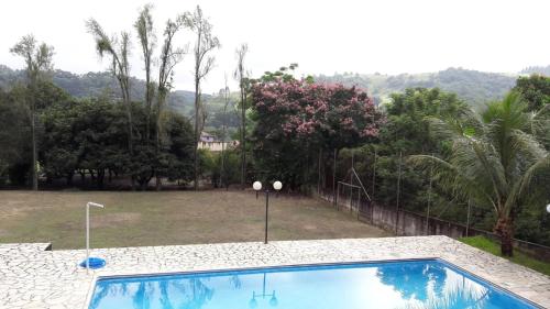 a swimming pool in a yard with trees at Casa de Campo "Recanto Céu Azul" in Guararema