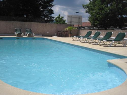 a large blue swimming pool with lounge chairs at Hotel Des Négociants in Lamastre