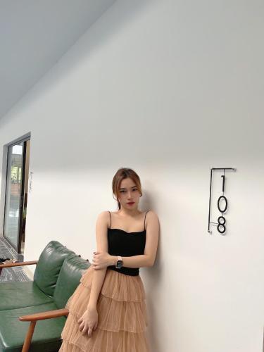 a woman in a dress leaning against a wall at Bông Villa Hotel & Apartment in Kon Tum