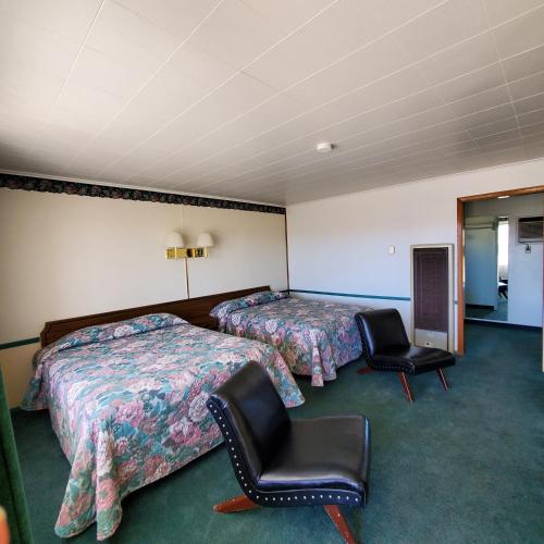 a hotel room with two beds and two chairs at Robin Hood Motel in Raton
