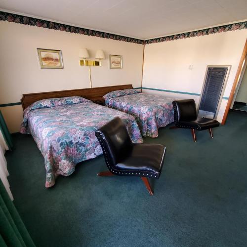 a hotel room with two beds and two chairs at Robin Hood Motel in Raton