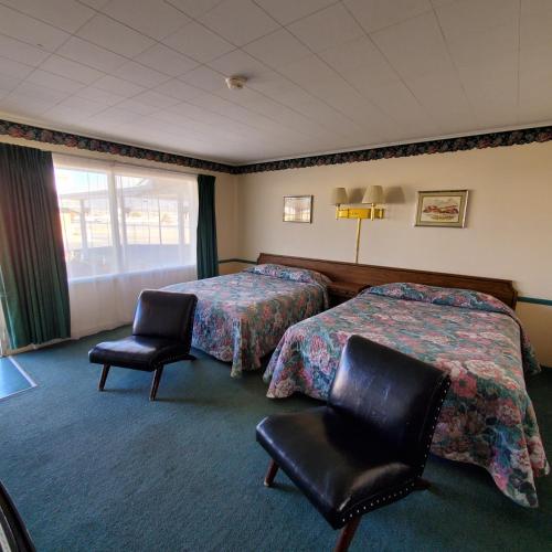 pokój hotelowy z 2 łóżkami i 2 krzesłami w obiekcie Robin Hood Motel w mieście Raton