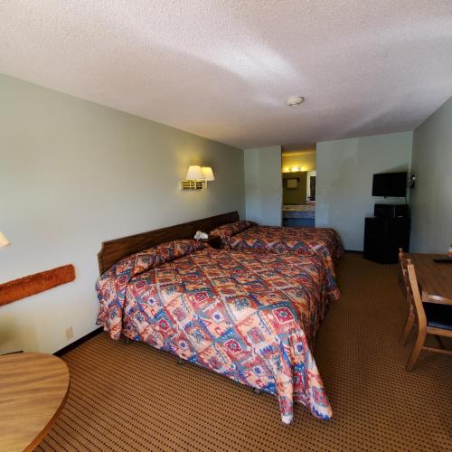 a hotel room with a bed and a table at Robin Hood Motel in Raton