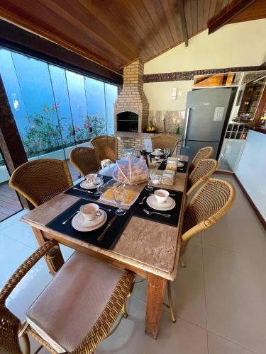 una sala da pranzo con tavolo e sedie in legno di Búzios House Oficial a Búzios