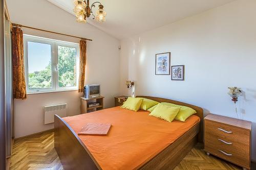 a bedroom with a large bed with yellow pillows at Villa Leo in Jesenice