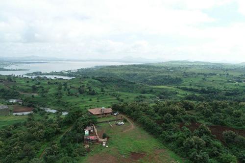 an aerial view of a house in the middle of a field at EZE NOF - A hilltop villa with 360º water view in Nashik