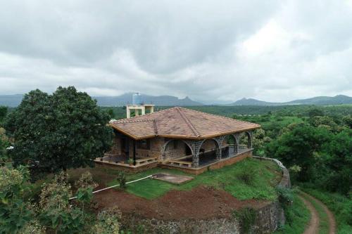 ein großes Haus auf einem Hügel in der Unterkunft EZE NOF - A hilltop villa with 360º water view in Nashik