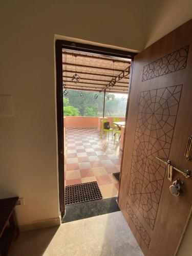 an open door to a patio with a table and a dining room at Erisha Tadoba in Mohurli