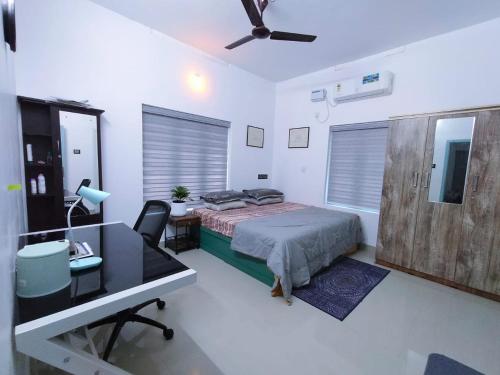 a bedroom with a bed and a desk and a deskablish at Bodhi garden villa in varkala in Varkala