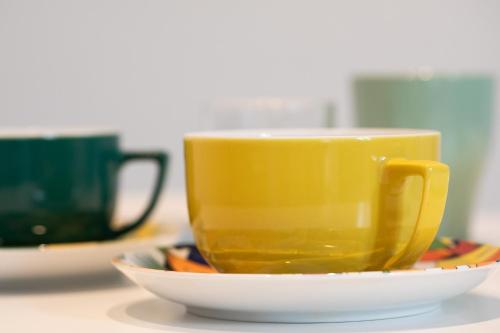 a yellow coffee cup on a plate on a table at AUDREY-Quartier Mairie-arènes antiques in Périgueux