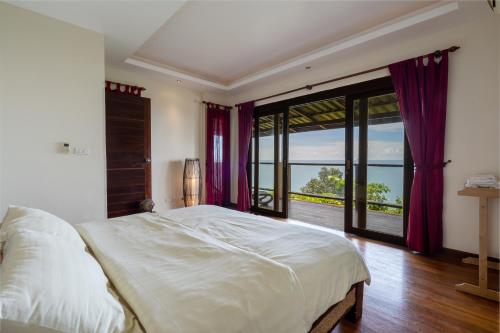 ein Schlafzimmer mit einem großen Bett und einem großen Fenster in der Unterkunft Eagles Nest Villa in Ko Lanta