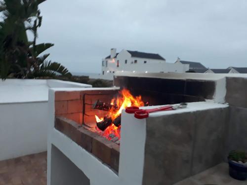 a fire in a brick oven on a patio at Beachway on Golden Mile in St Helena Bay