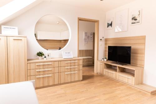 a living room with a tv and a mirror at Vigorous Bled Apartment in Bled