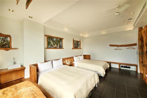 two beds in a room with white walls at Shangrila Leisure Farm in Dongshan