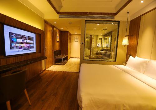 a hotel room with a bed and a flat screen tv at Radisson Bhopal in Bhopal