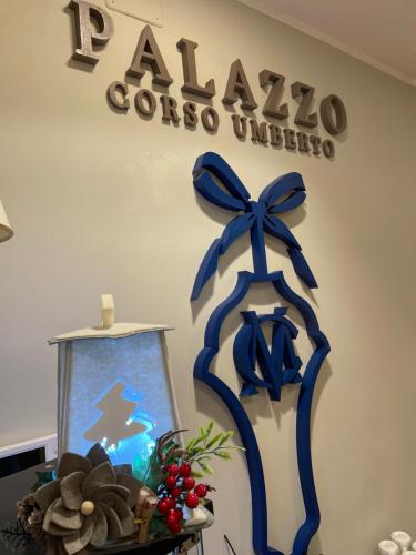 two blue bows on a wall with a sign at Boutique Hotel Palazzo Corso Umberto in Boiano