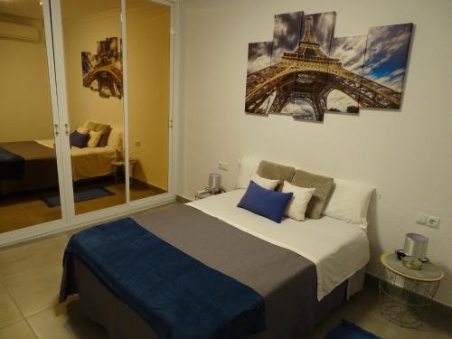 una camera con letto e una foto della torre Eiffel di Casasjerezanas VistaFlor a Jerez de la Frontera