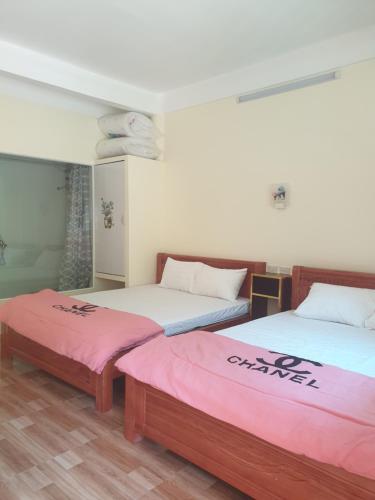 een kamer met 2 bedden met roze lakens bij HOMESTAY PAC BO CAO BẰNG in Cao Bằng