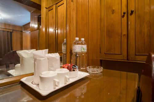 a kitchen counter with a tray with cups and bottles of water at Magpie Mall Road Residency (MG Marg) in Gangtok