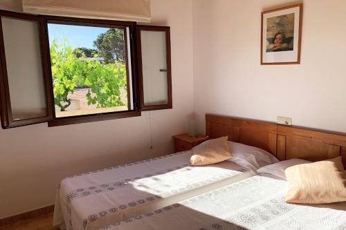 um quarto com uma cama e uma janela em Aptos rurales Can Pep de Sa Barda - Viñedos y tranquilidad em Sant Francesc Xavier