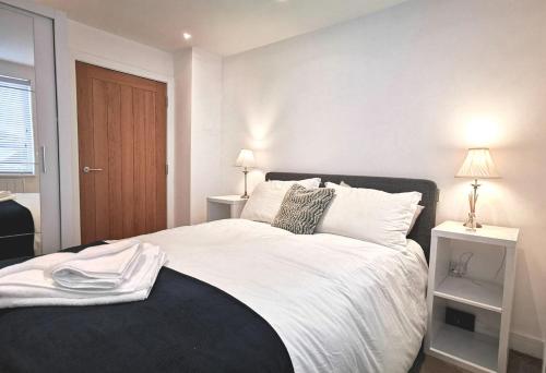 a bedroom with a large bed with white sheets and pillows at No.2 Horizon - Apartment in East Wittering Village in Chichester