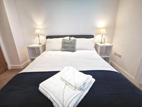 a bedroom with a large white bed with two night stands at Apartment in the heart of East Wittering Village in Chichester