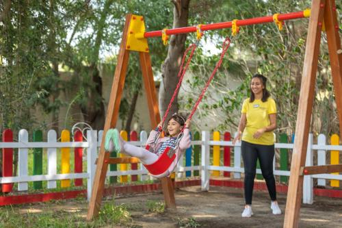 a young girl swinging on a swing with a woman at Steigenberger Marhaba Thalasso Hammamet in Hammamet