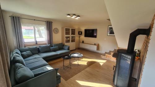 a living room with a blue couch and a fireplace at Załakowo, Na Gwizdówce 11 in Załakowo