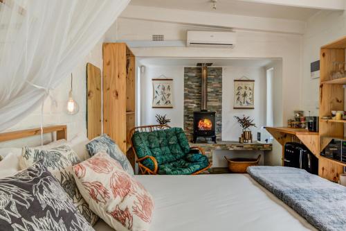 a bedroom with a bed and a couch and a fireplace at 4 ON REGENT in Greyton