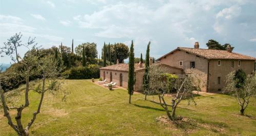an old house in a field with trees in front of it at Lavacchio 10 by Salogi Villas in Montalcino