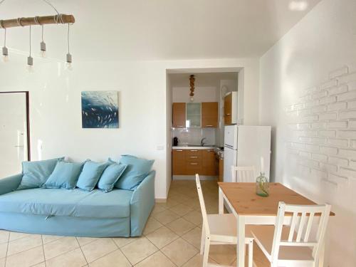 a living room with a blue couch and a table at La perla del Porto in Porto Recanati