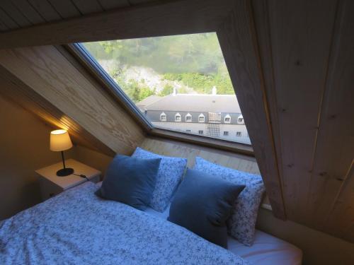 a bed in a room with a large window at Ático Dúplex reformado con vistas a la montaña in Canfranc-Estación
