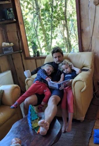 a man and two children sitting on a couch at Cabañas Natural Park Lodge Pucón in Pucón