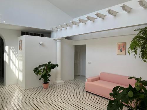 a living room with a pink couch and plants at Hotel Paraíso Del Mar in Nerja