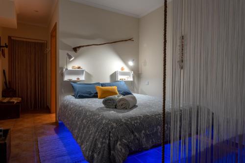 1 dormitorio con 1 cama con almohadas azules y amarillas en Sunset Room - Hiking & Beach en Odeceixe